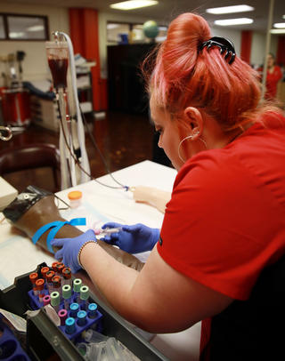 Phlebotomy Student Sticking Needle Into a Lab Dummy Arm