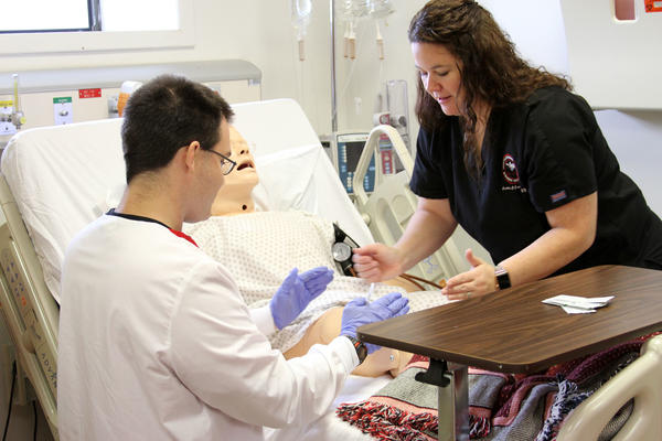 Nursing Student and Instructor Checking Vitals on a Training Dummy