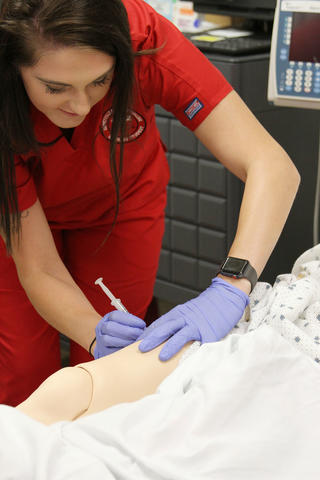 Nursing Student Learning How to Insert Needle Into Arm
