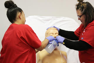 Nursing Students Performing Procedure on a Lab Dummy