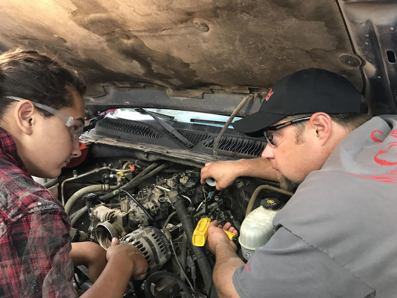 Instructor Examining Engine With Student