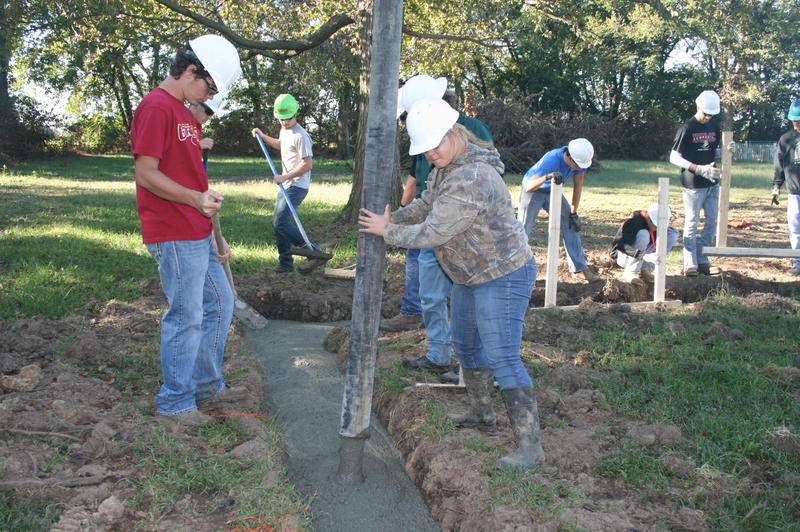 Students Pouring Concrete Into Footings for Foundation