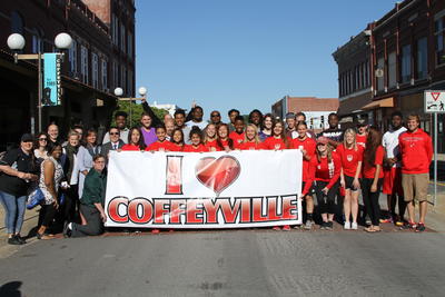 Group of Local Citizens Holding Up a Large "I Love Coffeyville" Banner